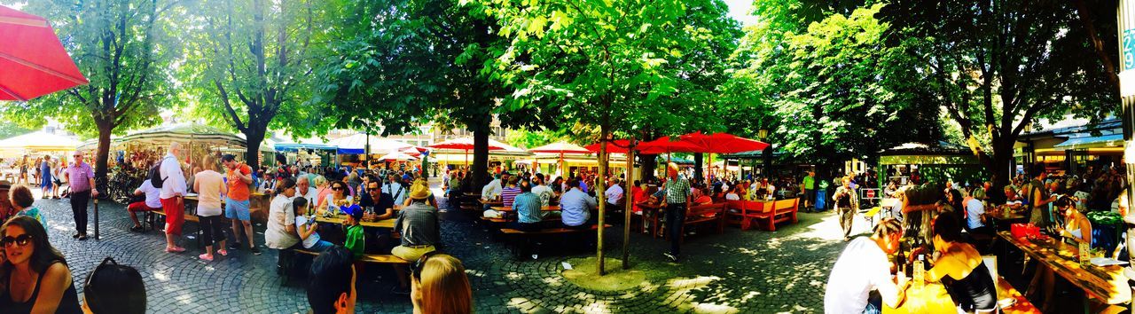 tree, large group of people, men, person, multi colored, hanging, lifestyles, day, outdoors, tradition, leisure activity, cultures, celebration, panoramic, in a row, incidental people, mixed age range, umbrella, crowd