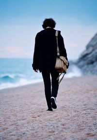 Rear view of person walking at beach