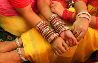 Cropped image of brides wearing bangles