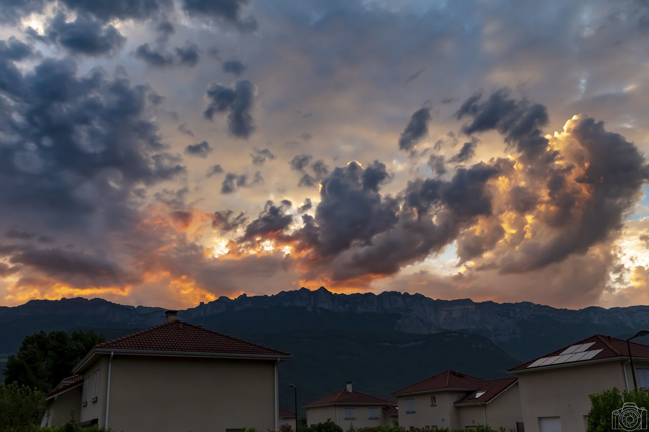 cloud - sky, sky, architecture, built structure, building, building exterior, sunset, house, nature, mountain, beauty in nature, scenics - nature, no people, residential district, orange color, dramatic sky, city, outdoors, overcast, ominous