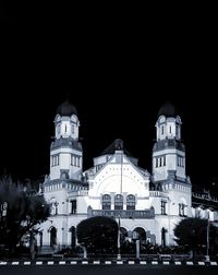 Low angle view of illuminated buildings against sky at night