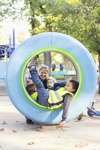 Teacher and children playing in tube