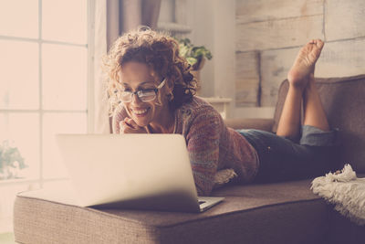 Young woman using mobile phone at home