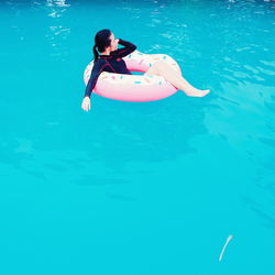 Full length of woman on inflatable ring in swimming pool