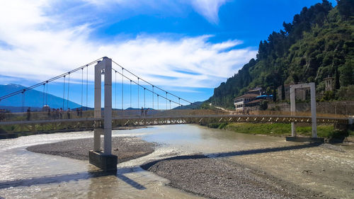 Bridge over road against sky in city