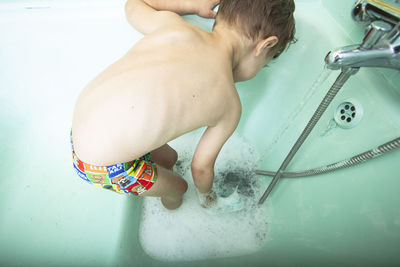 High angle view of shirtless boy in bathroom