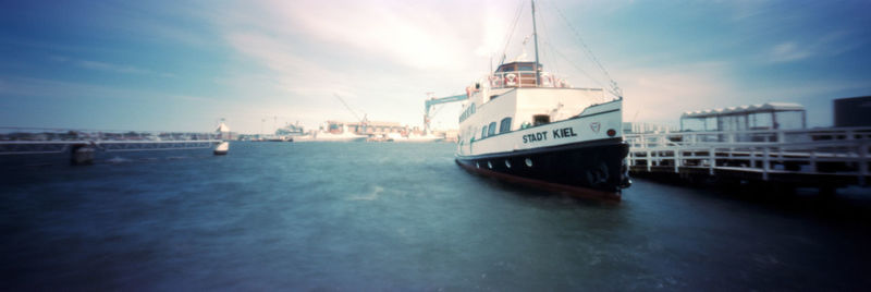 Ship moored at harbor against sky