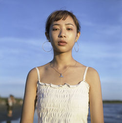 Portrait of young woman standing at beach