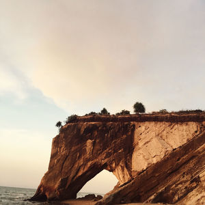 Rock formations by sea against sky