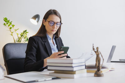 Businesswoman using laptop while sitting on table