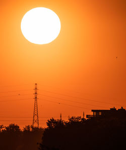 Silhouette trees against orange sky during sunset