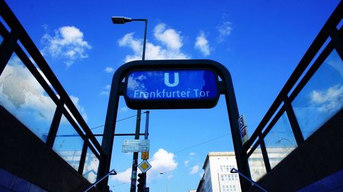 Low angle view of road sign against blue sky
