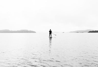 Man standing in sea against sky