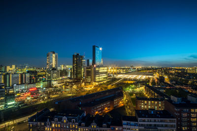 High angle view of illuminated cityscape against clear sky at dusk