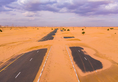 Scenic view of desert road against sky