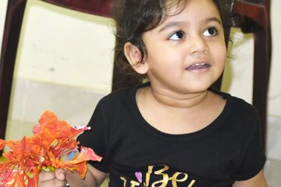 Portrait of cute girl with red flower