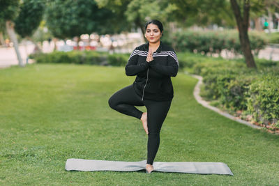 A young woman performing yoga asana outdoors. an indian woman practices yoga in the park.