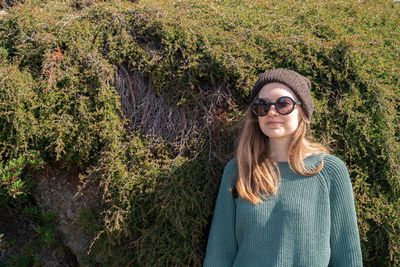 Portrait of smiling young woman against plants