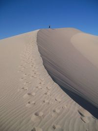 Distance view of person at desert against sky