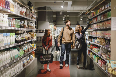 Smiling family with daughter shopping in supermarket