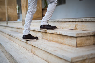 Low section of man standing on staircase