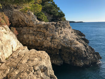 Rock formation on sea against sky