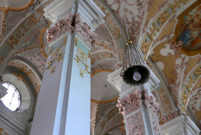Low angle view of chandelier hanging on ceiling of building