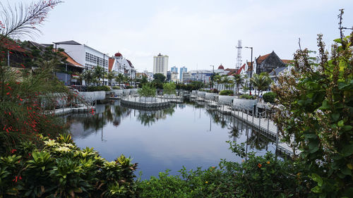 Scenic view of canal by buildings against sky