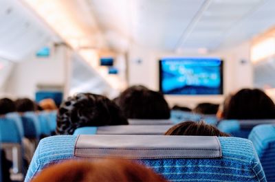 Rear view of people sitting in airplane