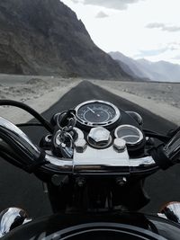 Bicycle parked by road against mountains