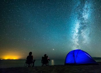 People sitting against star field at night