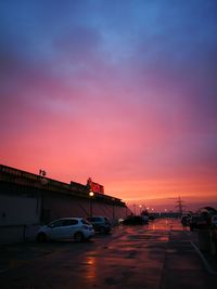 Cars on road against sky during sunset