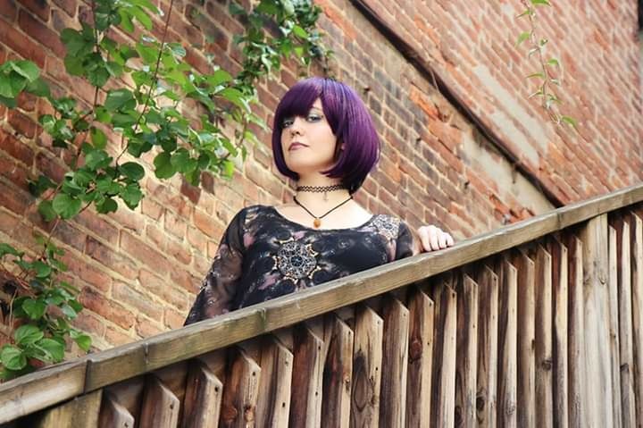 one person, young adult, lifestyles, portrait, young women, railing, leisure activity, real people, casual clothing, looking at camera, women, architecture, wall, beautiful woman, looking, built structure, day, hairstyle, outdoors, contemplation, brick, bangs