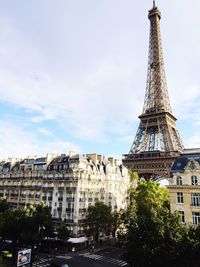 Eiffel tower and buildings in city against sky