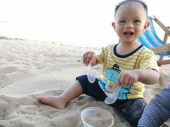 Cute boy sitting on beach