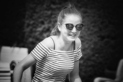 Smiling young woman wearing sunglasses on sunny day