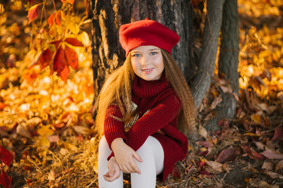 Cute baby girl with long hair in autumn in the park smiling and enjoying a sunny day