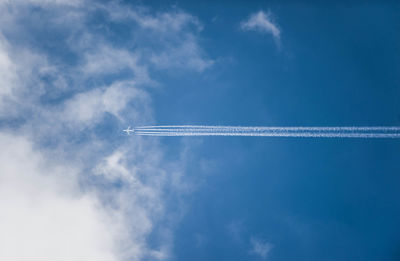 Low angle view of vapor trail against blue sky