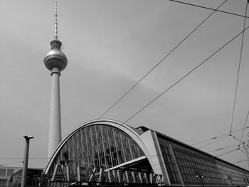 Low angle view of communications tower and buildings against sky