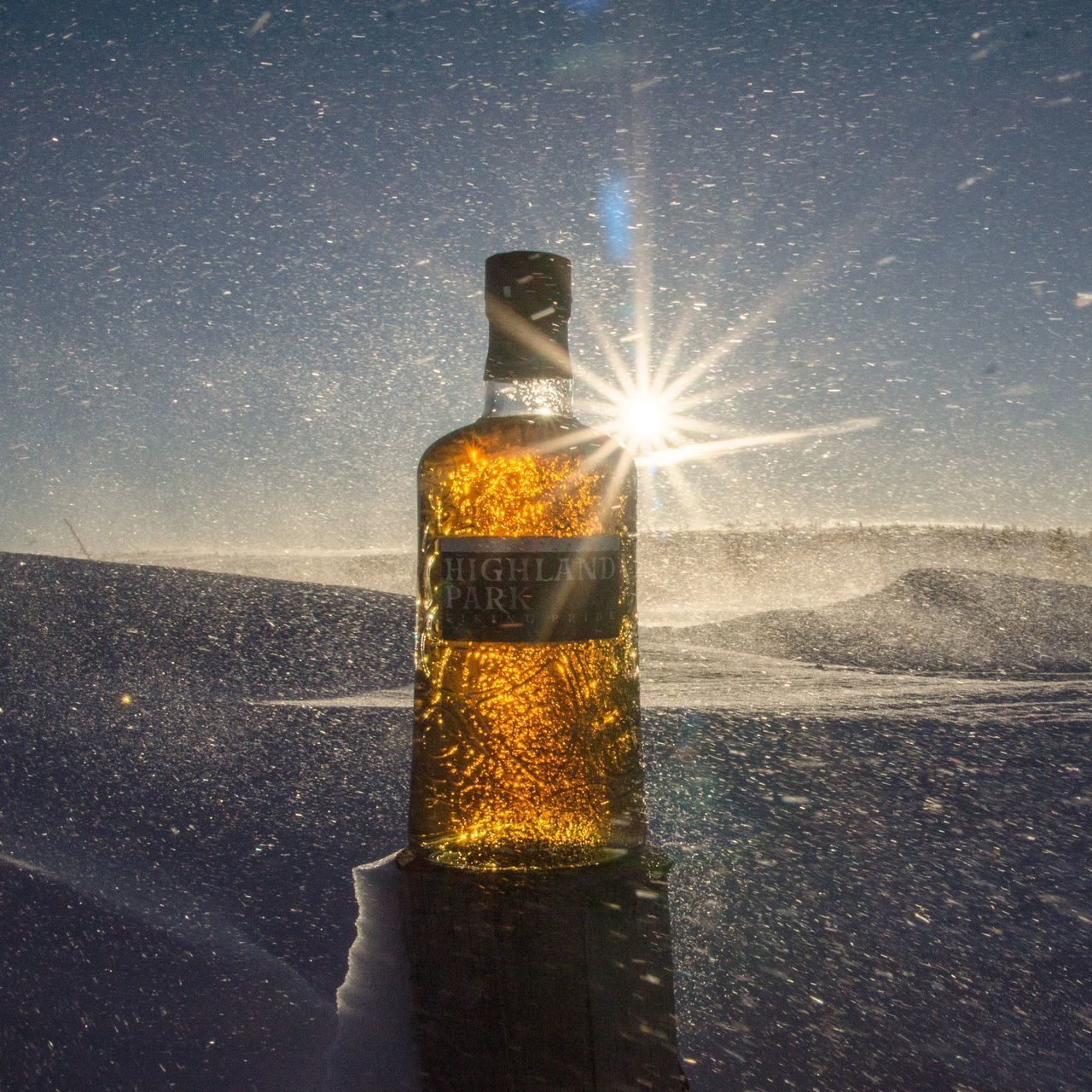 DIGITAL COMPOSITE IMAGE OF GLASS AND BOTTLE AGAINST SKY