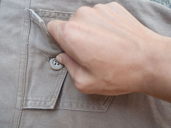 Close-up of man touching button of pocket