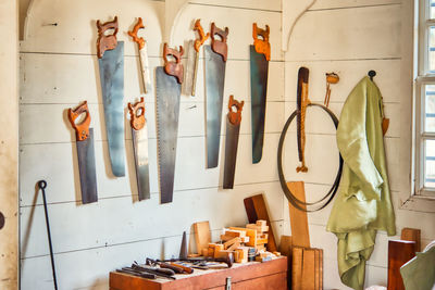 Hand saw with equipment hanging on wall