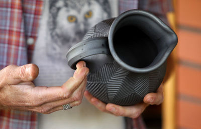 Midsection of man holding earthenware