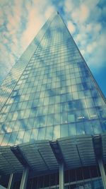 Low angle view of modern building against cloudy sky