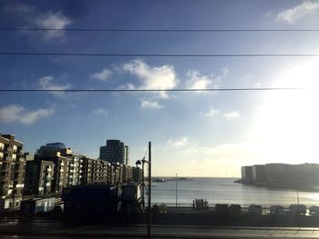 Scenic view of sea and cityscape against sky