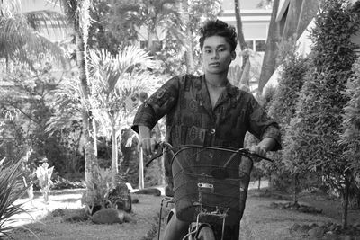 Portrait of young man riding bicycle in park