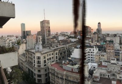 Aerial view of buildings in city against sky during sunset