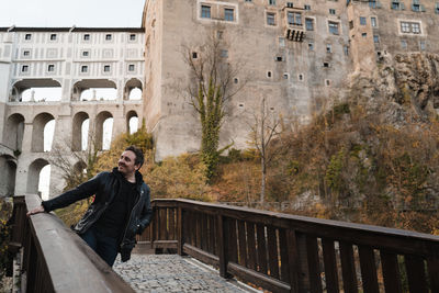 Full length of woman standing on railing against bridge