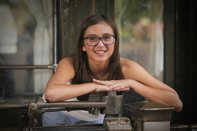 Portrait of smiling girl leaning on metallic equipment