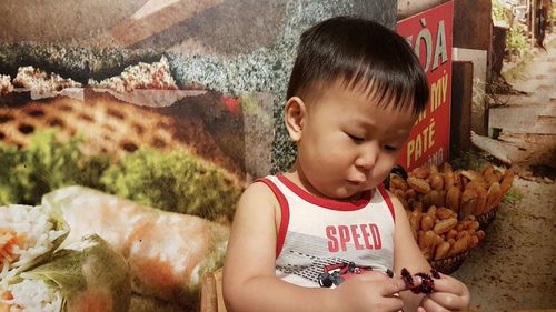 Cute boy playing with tinsel against poster